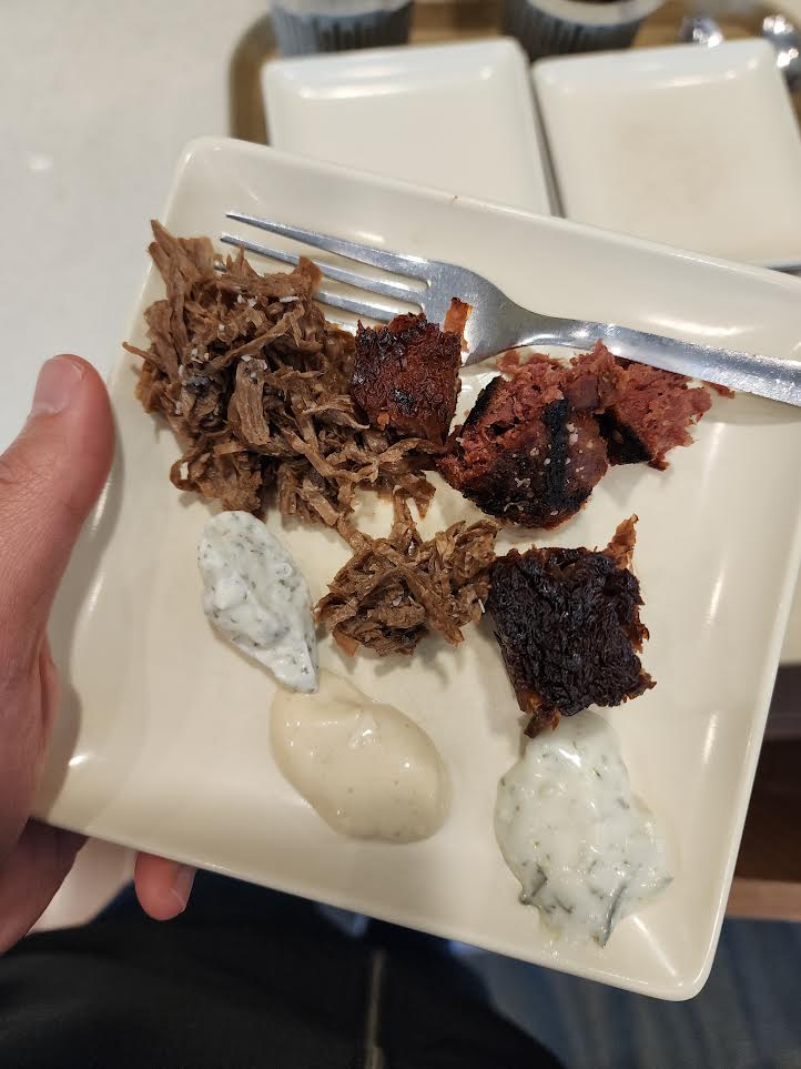 A plate of plant-based dishes with dipping sauces